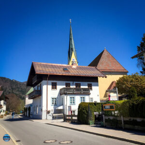 Haus in Rottach-Egern in der Seestraße, im Hintergrund ist der Kirchturm. Ort in Oberbayern